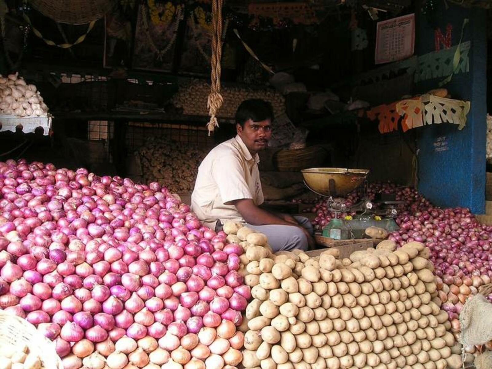 Фермеры Индии сидят с огромным урожаем томатов и картофеля